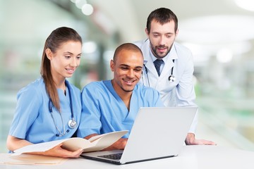 Fototapeta na wymiar Doctors team talking expertise in hospital by laptop