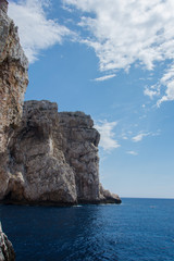 Fototapeta na wymiar Scogliera altissima a picco sul mare in Sardegna vista dal sentiero che porta alla grotta di Nettuno