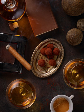 Still life with cognac glasses, cigar and pralines