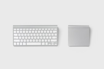 Wireless computer keyboard and trackpad isolated on soft gray background.