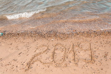 Summer drawn letters on a sandy beach. Text template pattern. Creative typography for holiday greetings.