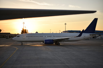 medium range passenger low-cost aircraft in airport on sunrise