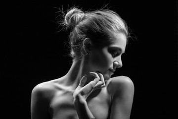beautiful sensual young woman with bare shoulders on black background, monochrome