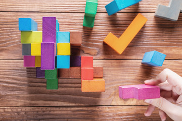 Concept of decision making process, logical thinking.  Hand holding wooden puzzle element.