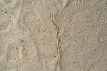Sand on the beach with footprints and shoes. Many footprints with shoes and without shoes.