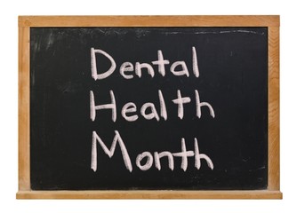 Dental Health Month written in white chalk on a black chalkboard isolated on white