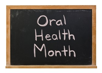 Obraz premium Oral Health Month written in white chalk on a black chalkboard isolated on white