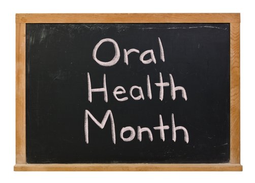 Oral Health Month Written In White Chalk On A Black Chalkboard Isolated On White