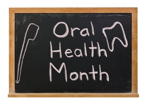 Oral Health Month Written In White Chalk On A Black Chalkboard Isolated On White