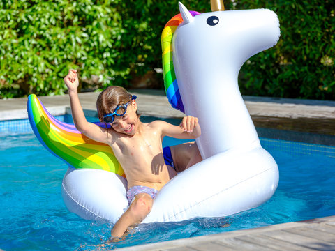 Boy swimming on unicorn float