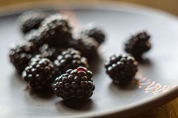large juicy blackberry berries on a ceramic plate