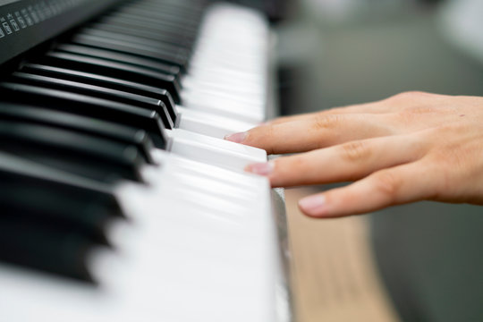 close up hands playing different chords on piano keys f