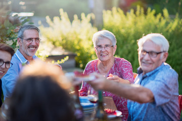 Summertime, cheerful family gathered for picnic in the garden