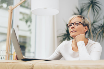 Mature blond woman sitting deep in thought