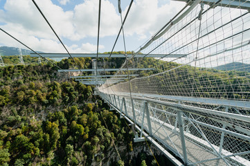 Metal suspension bridge over the abyss, side view