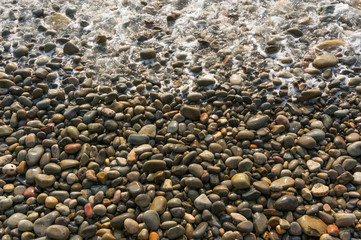 Waves washing small stones, top view