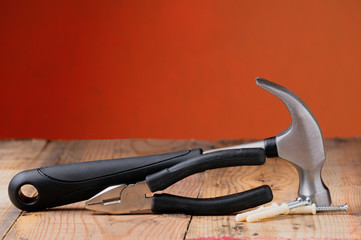 Hammer and pliers on the workbench, screws