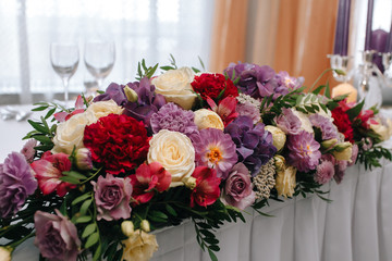 Bright floral arrangement on the wedding table newlyweds