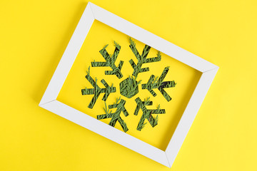 Snowflake in picture frame abstract on yellow.