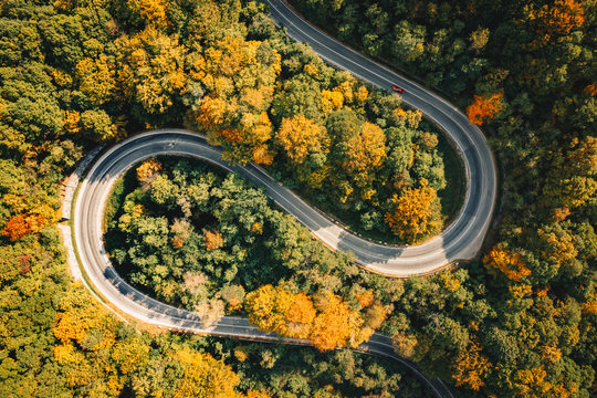 Extreme curved winding road in the forest aerial photography
