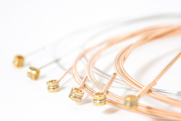 Set of bronze strings for acoustic guitar isolated / Set of twisted guitar strings isolated on...