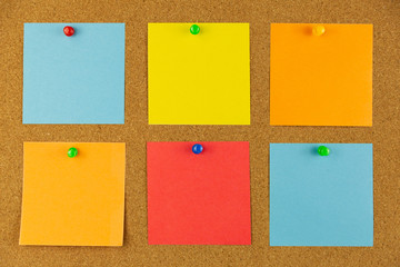 Colorful paper pined to cork board as reminders.