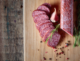 Smoked salami on a old wooden table.