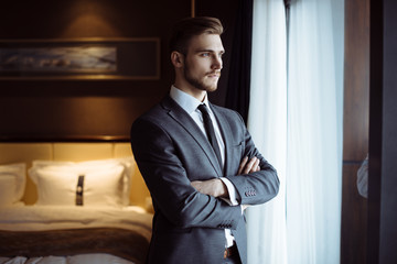 Young handsome man relaxing at his apartment in a hotel after business meeting. Business trip....