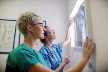Orthopedists looking at X-ray.  Consulting room interiour. - obrazy, fototapety, plakaty