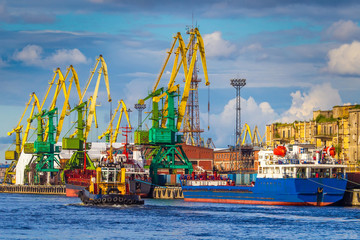 Naklejka premium Berth port. Unloading ships. Cranes unload ships. Merchant navy.