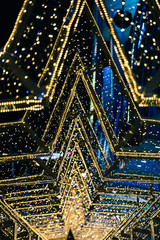 The shining decoration of streets of the night city in the form of a star. Stars stand one after another, creating the portal from the shining fires