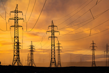 Silhouette of high voltage posts at sunset. Norilsk.