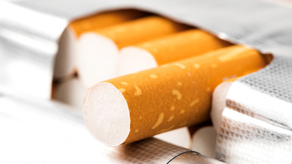 Cigarettes in a pack closeup on white background. Smoking tobacco. Bad habit