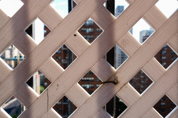 Abstract lattice fence wall with urban city skyline background. Abstract minimal photography design and detail. Architectural abstract background. 