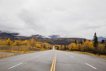 empty road in the Alaskan mountains on a cloudy autumn day