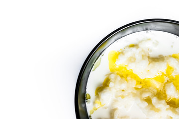 tasty rice porridge with butter in a black bowl with a blackl spoon, healthy food, diet