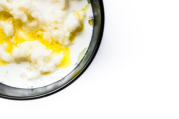 tasty rice porridge with butter in a black bowl with a blackl spoon, healthy food, diet