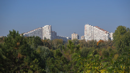 Fototapeta premium Views of the city of Chisinau on the horizon. White beautiful house among the green trees. 