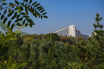 Fototapeta na wymiar Views of the city of Chisinau on the horizon. White beautiful house among the green trees. 