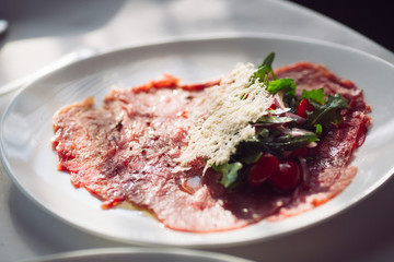 Red beef carpaccio in a white plate