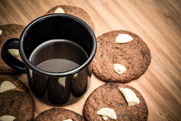 Chip cookies homemade with white chocolate and a cup of black coffee. Delicious.