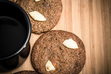 Chip cookies homemade with white chocolate and a cup of black coffee. Delicious.