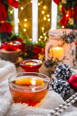 Christmas holiday composition Cup with hot tea with candles, gifts, a cozy fluffy blanket. The concept of peace and comfort at home in Christmas. New Year winter background greeting card