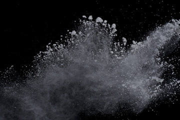 White powder explosion on black background. Dust splatted isolated. Paint Holi.