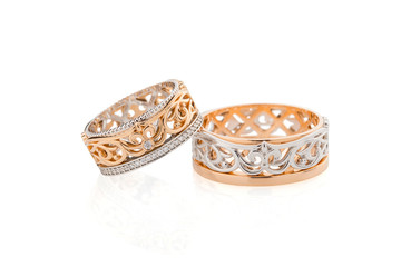 Pair of pink gold and white gold wedding ring with fleur de lis ornament isolated on white