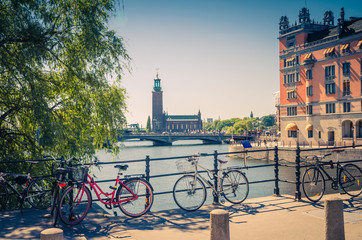 Bike near bridge railing and Stockholm City Hall (Stadshuset), Sweden - obrazy, fototapety, plakaty