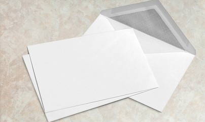 Blank white envelope and card on wooden background