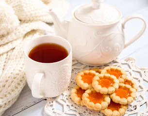  teapot, cup of tea and biscuits on the wooden table