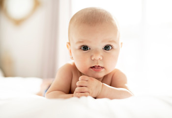 A Cute baby girl on a white bed at home