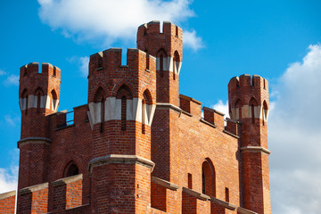 well-preserved towers of the old medieval castle of red brick against a blue sky